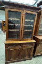 A Victorian mahogany bookcase with a moulded cornice above a pair of glazed doors,