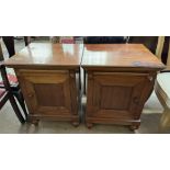 A pair of 20th century bedside cabinets with square tops and single cupboard doors on bun feet
