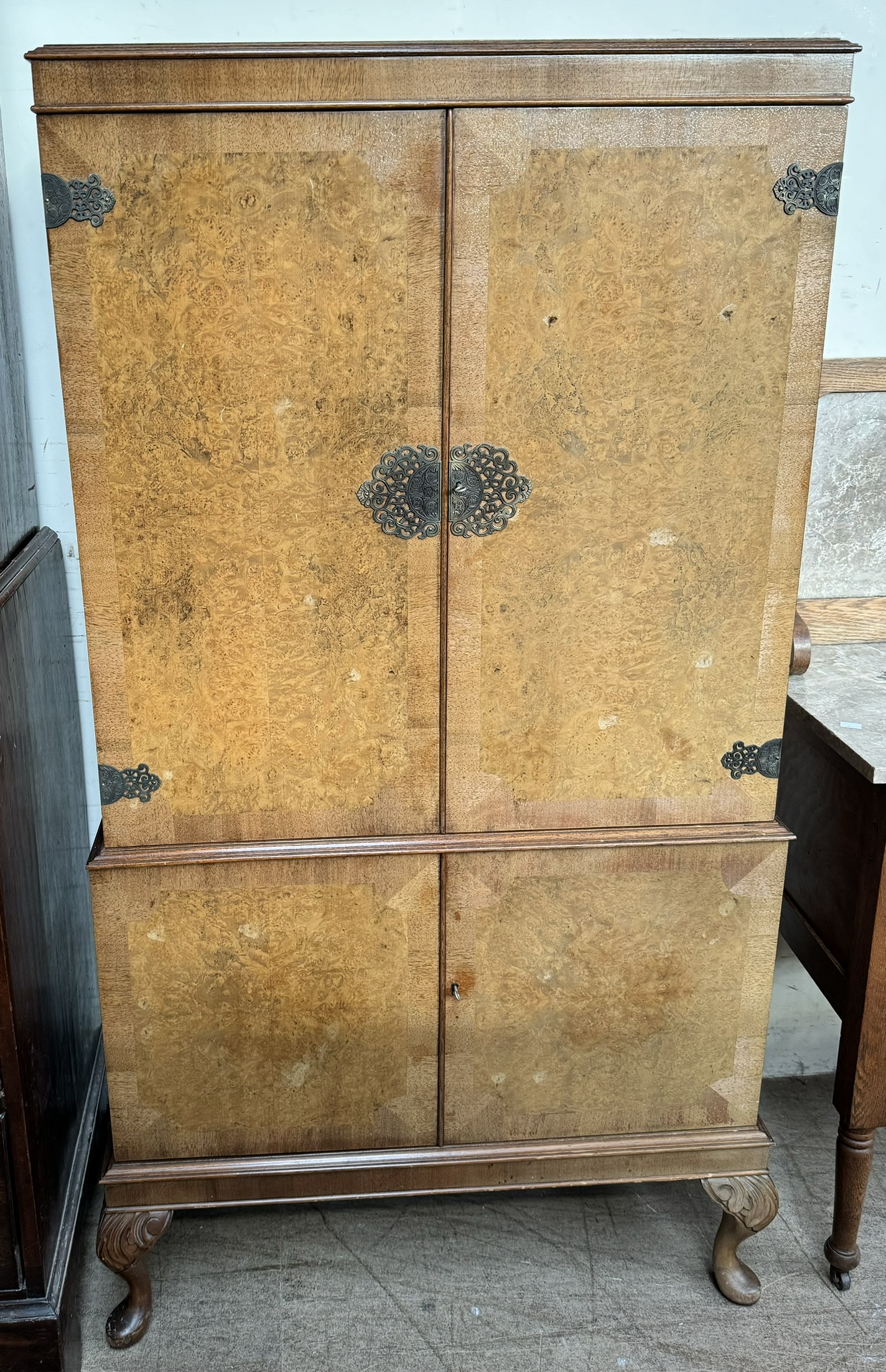 A 20th century walnut cocktail cabinet with a pair of cabinet doors enclosing a shelved mirrored