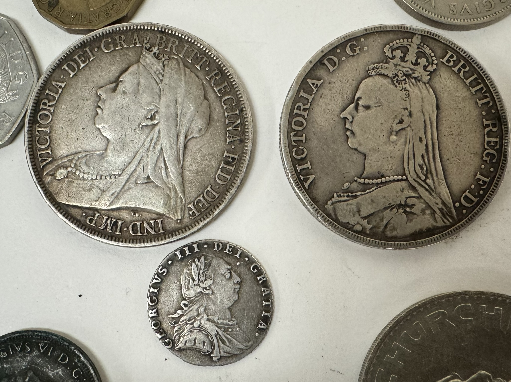 A George III sixpence dated 1787 together with two Victorian crowns,