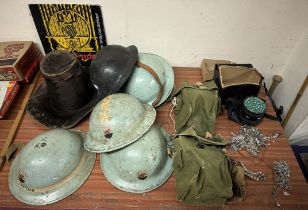 A Welsh seal skin hat together with military tin helmets, gas masks,