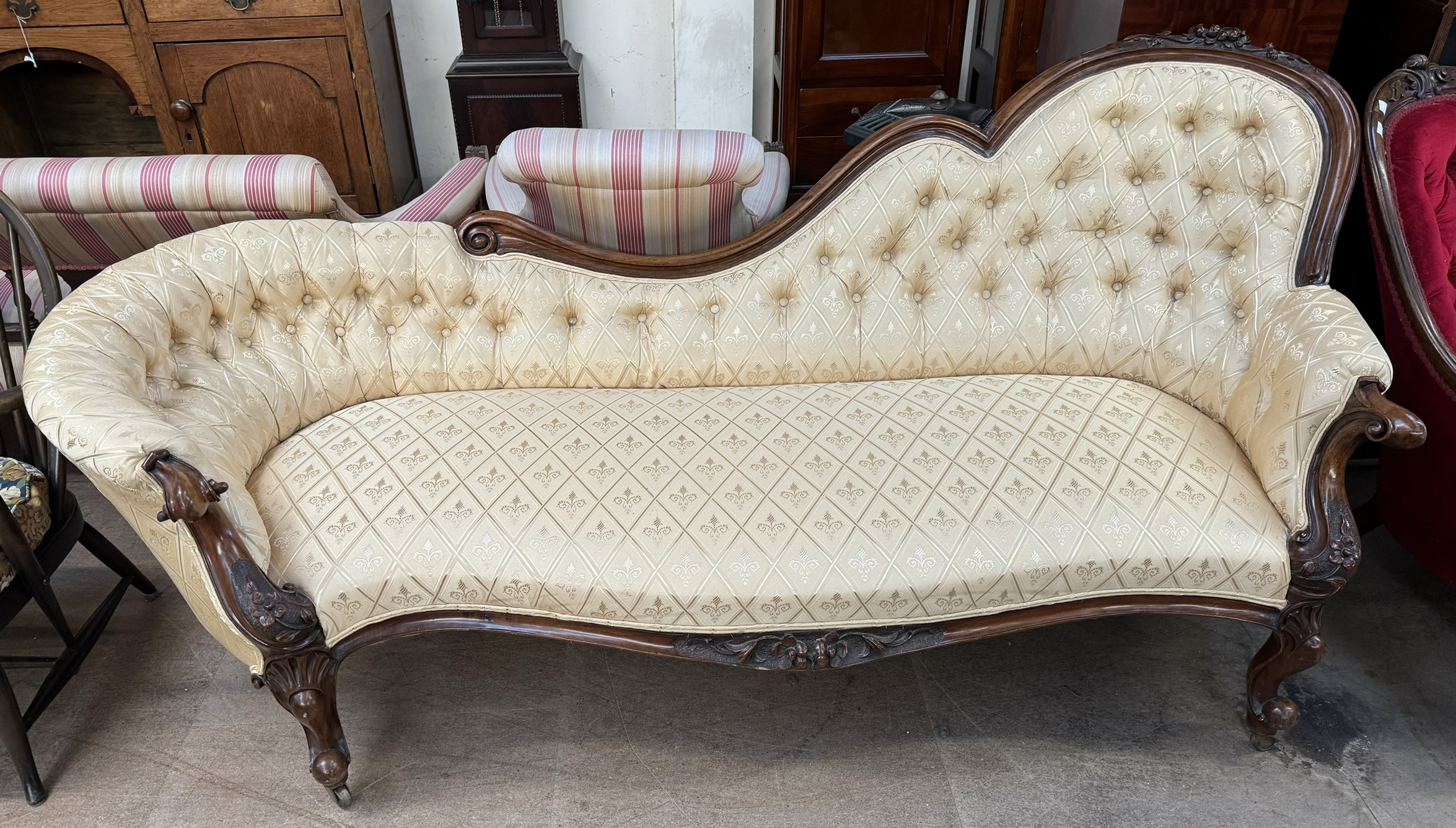 A Victorian walnut framed chair back settee carved with fruit and flowers with chequered yellow