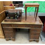 A reproduction yew pedestal desk together with a Singer sewing machine and an inlaid table