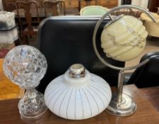 An Art Deco design glass lamp shade of spherical form on a stainless steel base together with