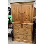 A pine linen cupboard, the top section with a pair of cupboard doors and shelves,