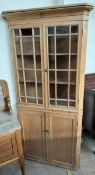 A 19th century pine standing corner cupboard with a pair of glazed doors with glazing bars the base