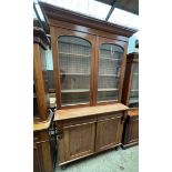 A large Victorian mahogany bookcase with a moulded cornice above a pair of glazed doors,