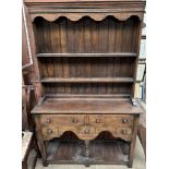 A 20th century oak dresser with a moulded cornice above two shelves,
