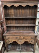 A 20th century oak dresser with a moulded cornice above two shelves,