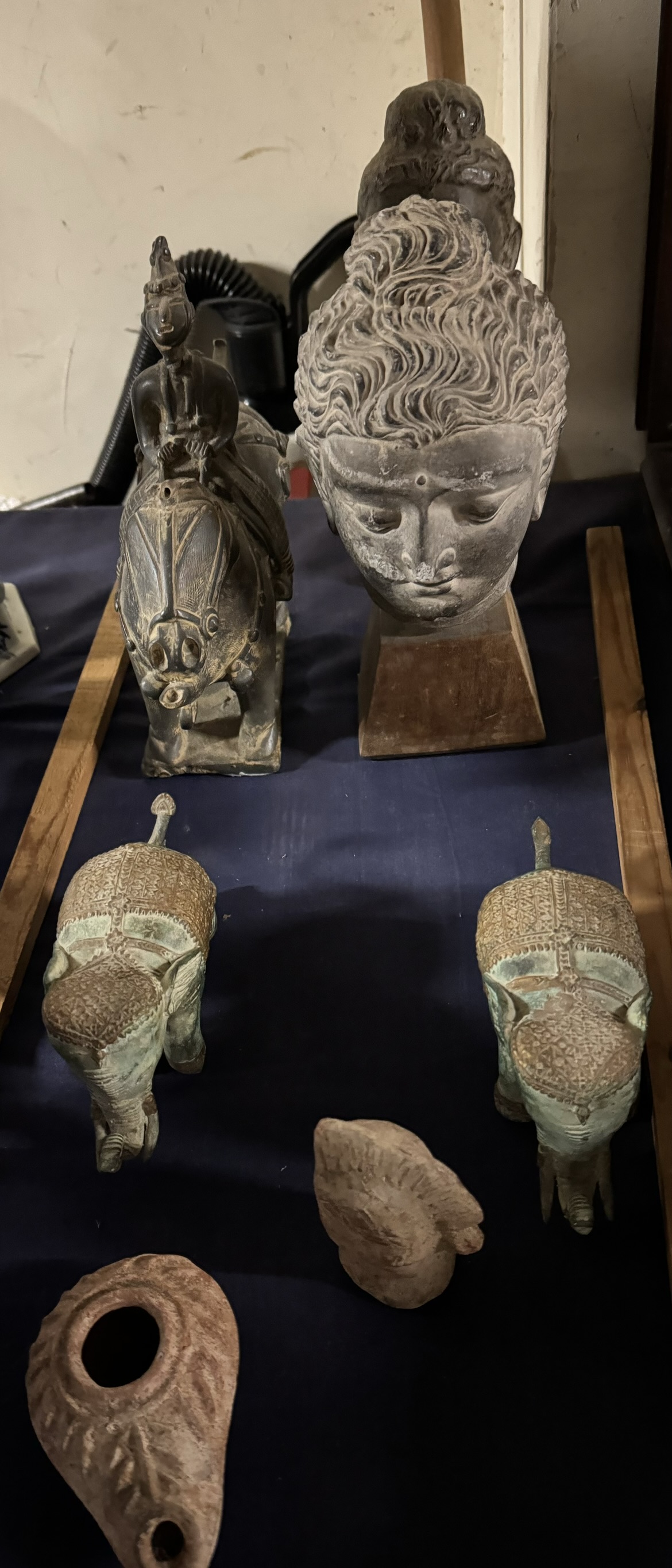 A replica of a Buddha together with other busts,