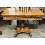 A Victorian oak card table with a crossbanded top above a moulded frieze and fold over baize top on