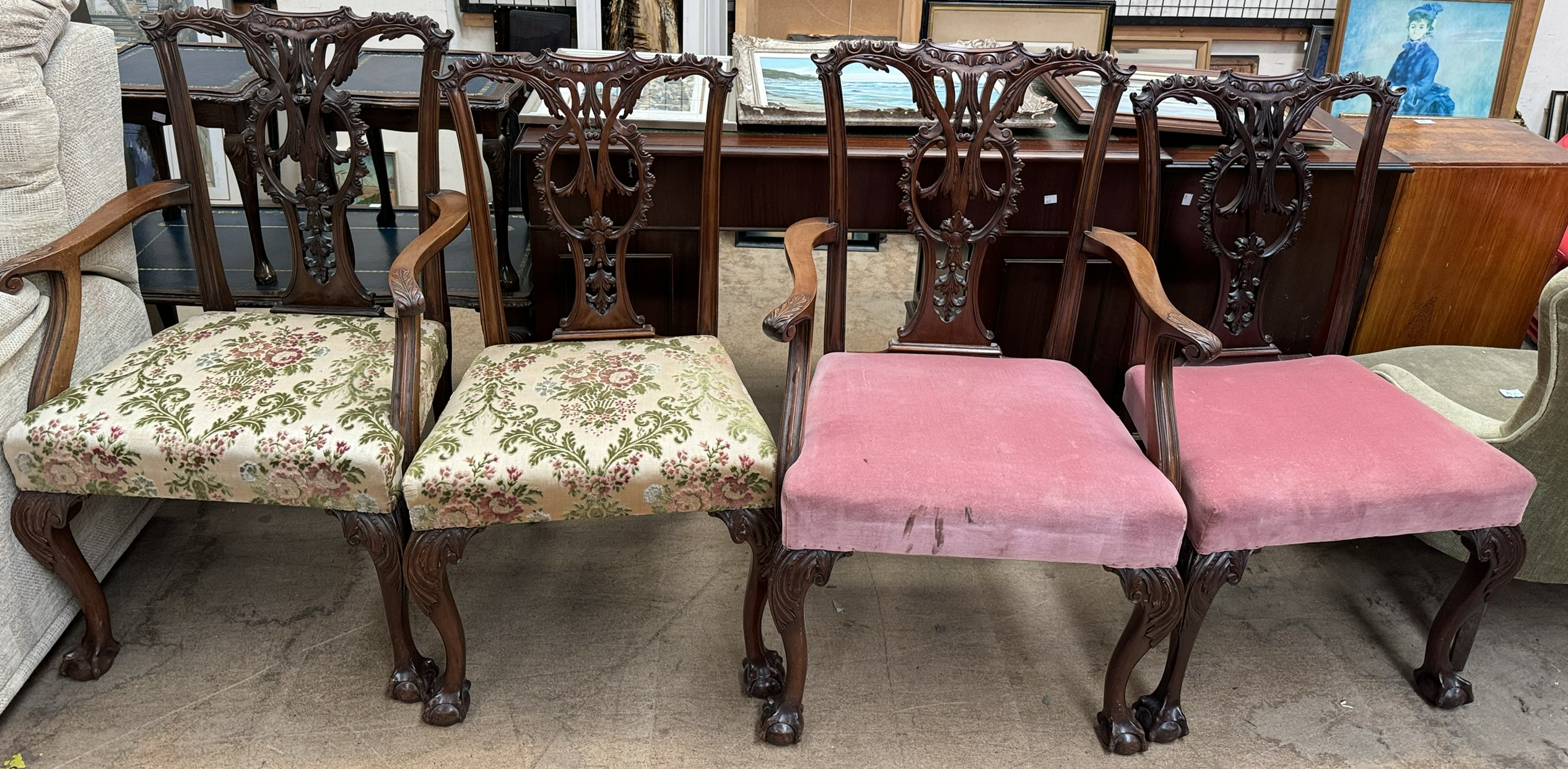 A set of four George III style mahogany dining chairs with a carved cresting rail and pierced vase