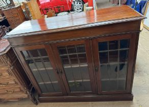 An early 20th century mahogany side cabinet with a rectangular top and moulded cornice above a pair