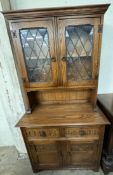 A 20th century oak dresser, the moulded cornice above a pair of glazed doors with leaded decoration,