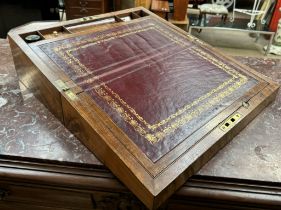 A 19th century walnut laptop desk with a foldover top enclosing a leather inset top and inkwells