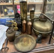 A brass goblin door stop together with a brass jug, brass tray, shell cases, lion carving,