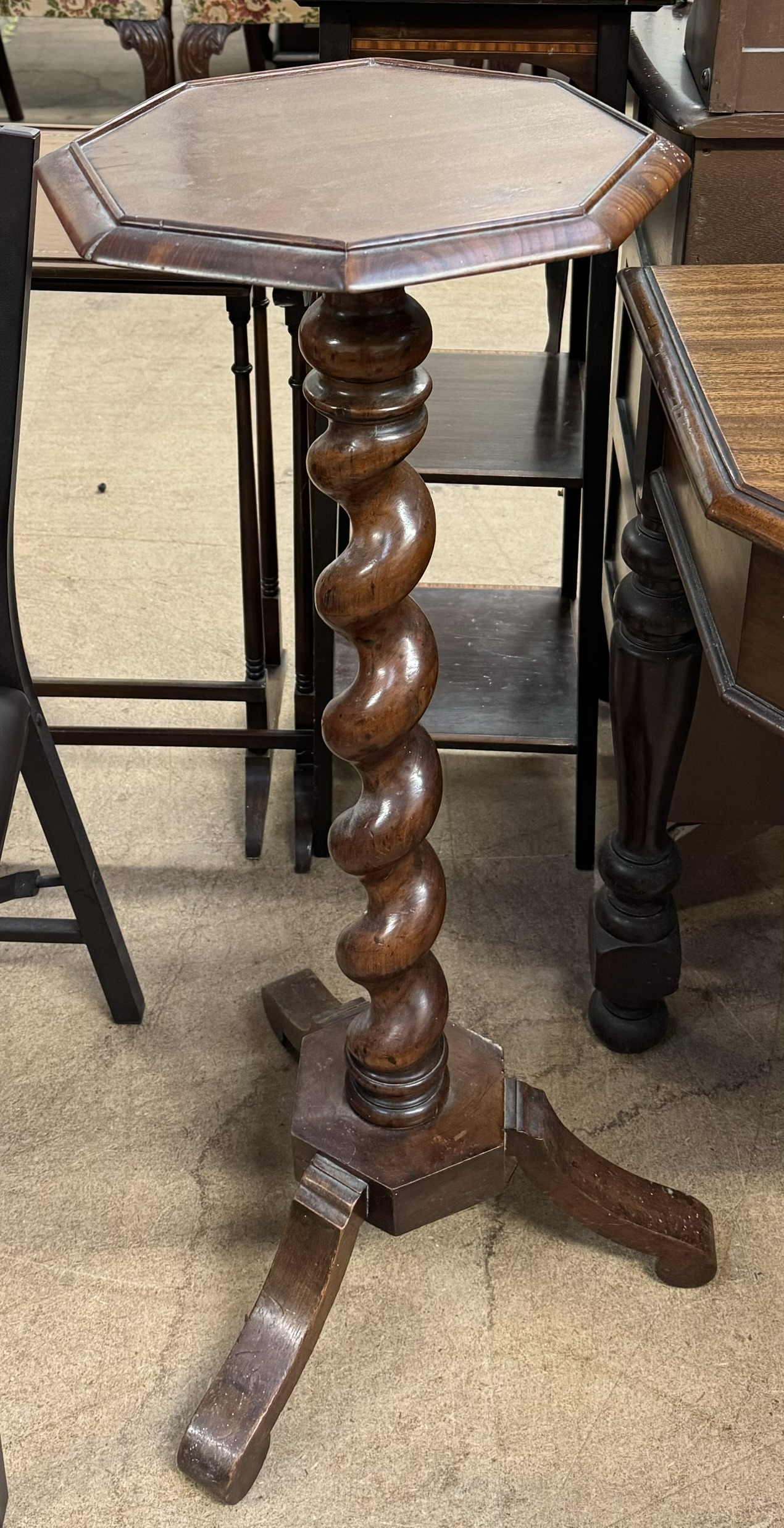 A Victorian mahogany torchere with an octagonal top on a barley twist column and tripod base