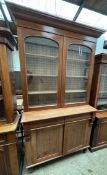 A large Victorian mahogany bookcase with a moulded cornice above a pair of glazed doors,