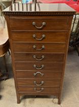 A mahogany music cabinet with a rectangular dentil moulded cornice above eight drawers with drop