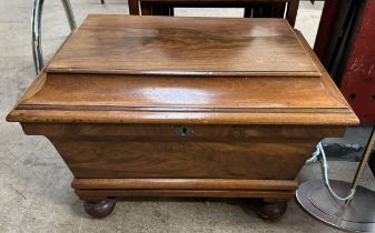 A Victorian mahogany cellaret / wine cooler of sarcophagus form on bun feet