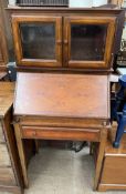 A 20th century mahogany bureau display cabinet with a glazed top and sloping fall on square