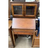 A 20th century mahogany bureau display cabinet with a glazed top and sloping fall on square