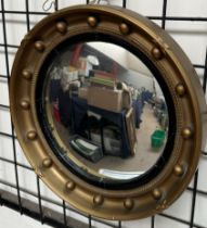 A convex wall mirror with ball decoration