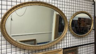 An oval gilt wall mirror with husk border together with another oval gilt wall mirror