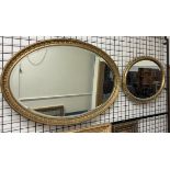 An oval gilt wall mirror with husk border together with another oval gilt wall mirror