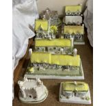 A Coalport porcelain model of The Village shop together with other Coalport cottages including The