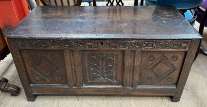 A late 17th / early 18th century oak coffer with a planked rectangular hinged top above a carved