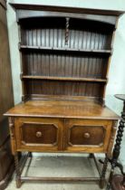 A 20th century oak dresser with a moulded cornice above two shelves,