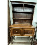 A 20th century oak dresser with a moulded cornice above two shelves,
