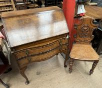 A 20th century walnut bureau with a sloping fall and two drawers on shell capped cabriole legs and