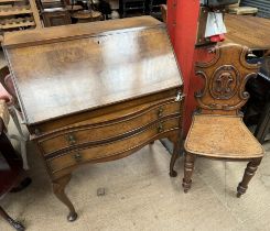 A 20th century walnut bureau with a sloping fall and two drawers on shell capped cabriole legs and
