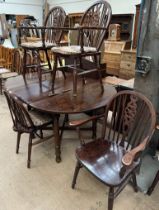 A 20th century oak extending dining table together with a set of six wheelback dining chairs