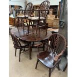 A 20th century oak extending dining table together with a set of six wheelback dining chairs