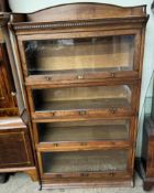 An oak sectional bookcase with an arched three quarter gallery and dentil moulded cornice above