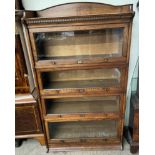 An oak sectional bookcase with an arched three quarter gallery and dentil moulded cornice above