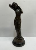 A bronzed figure of a maiden on a turned base