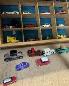 A collection of corgi and other model cars in a sectional shelf unit together with a boxed Corgi