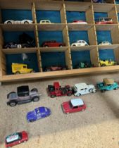 A collection of corgi and other model cars in a sectional shelf unit together with a boxed Corgi