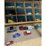 A collection of corgi and other model cars in a sectional shelf unit together with a boxed Corgi