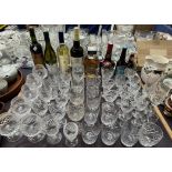 Assorted crystal drinking glasses together with a bottle of Amaretto, Tia Maria,