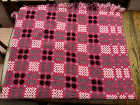 A Welsh blanket with a red ground and geometric patterns