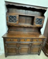 A 20th century oak dresser, the top with shelves and glazed cabinets,