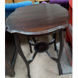 A mahogany occasional table with a shaped circular top on four square legs united by an undertier