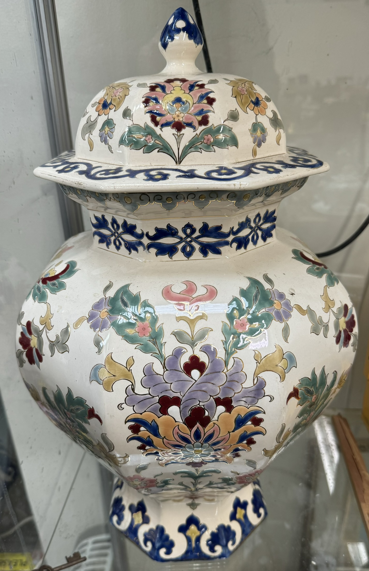 A large pottery vase and cover decorated with flowers and leaves