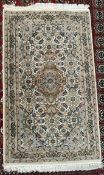 A rug with a cream ground decorated with interlaced flowers and leaves and guard stripes,