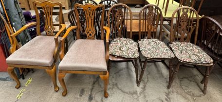 A set of three wheel back dining chairs together with a pair of modern elbow chairs